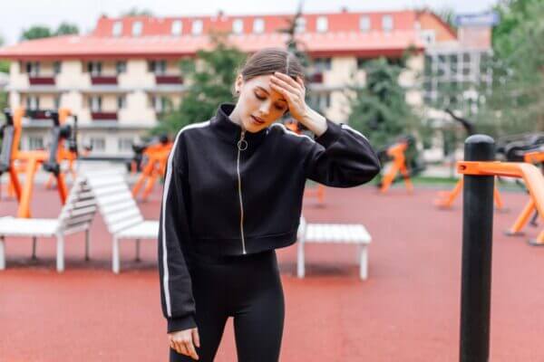 Person feeling dizzy after jumping jacks during cardio workout