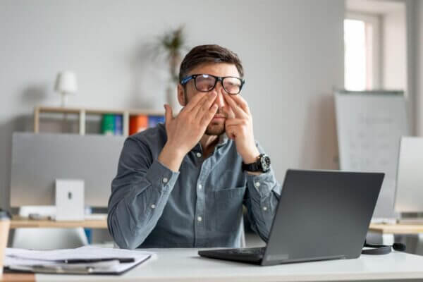 Person experiencing dry eyes after long computer screen use
