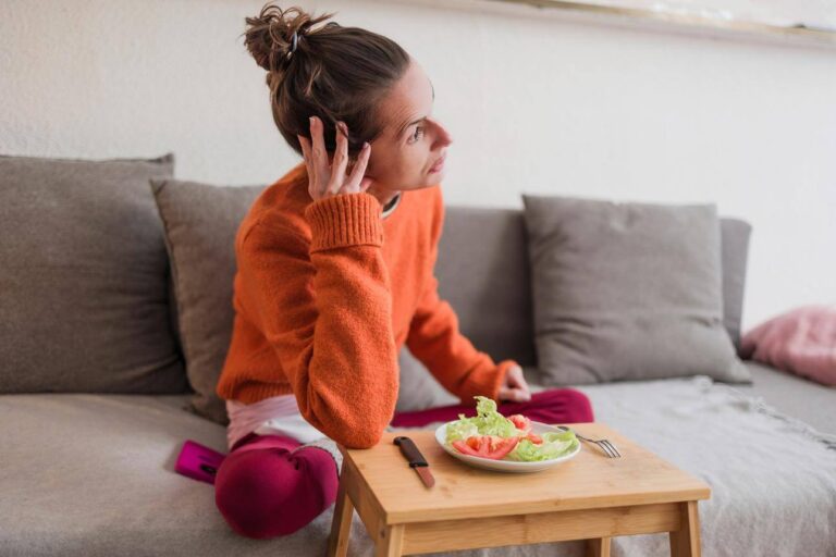 Person feeling uneasy and anxious after eating a meal at home