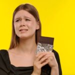 Person feeling anxious after eating chocolate at home