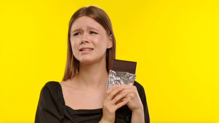 Person feeling anxious after eating chocolate at home