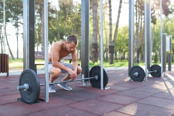 Man feeling dizzy after heavy squats in a gym