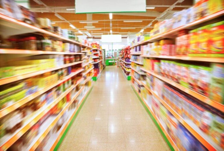 Person feeling dizzy under bright lights in a grocery store aisle