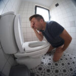 Person feeling faint and dizzy in the bathroom after a bowel movement