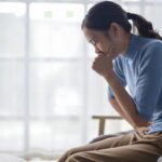 Person feeling nauseous and emotionally overwhelmed after crying