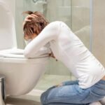 Person feeling nauseous and dizzy after a bowel movement in a bathroom