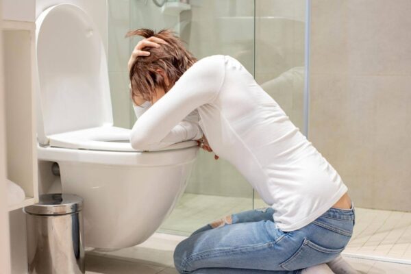 Person feeling nauseous and dizzy after a bowel movement in a bathroom