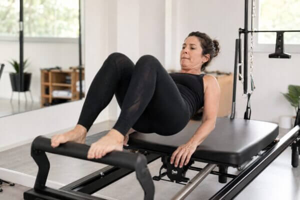 Person experiencing mild muscle shaking during a reformer Pilates exercise