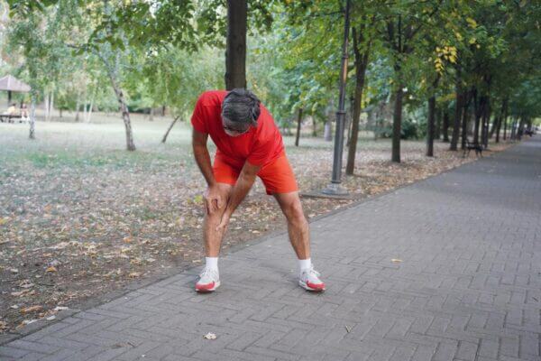 Person feeling sore after stretching hamstring muscles at home