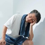 Person feeling tired and drained after a hot shower in a steamy bathroom
