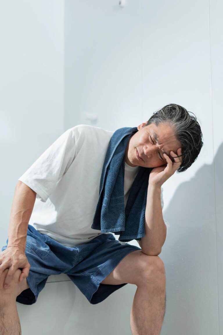 Person feeling tired and drained after a hot shower in a steamy bathroom