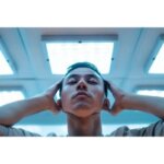 Person feeling dizzy and visually uncomfortable under bright fluorescent lights