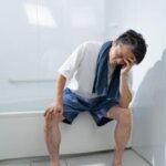 Person feeling dizzy after standing up from a hot bath