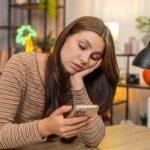 Person feeling mentally foggy after scrolling on a smartphone at night