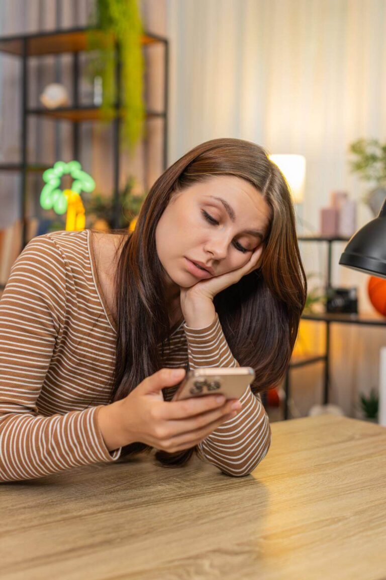 Person feeling mentally foggy after scrolling on a smartphone at night