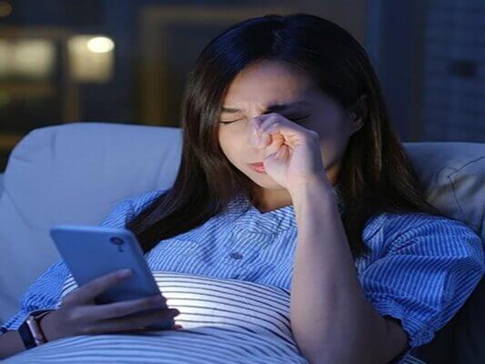 Person squinting while scrolling on a smartphone screen