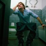 Person experiencing poop sweats and dizziness during a bowel movement