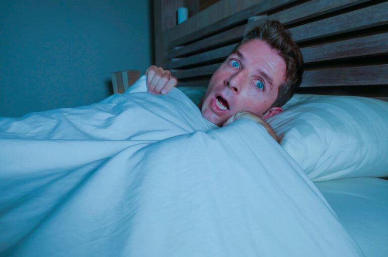 Person experiencing a sinking feeling while falling asleep in bed