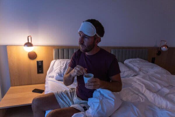 Person lying awake in bed after drinking tea at night