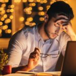 exhausted person awake in bed late at night despite feeling tired all day