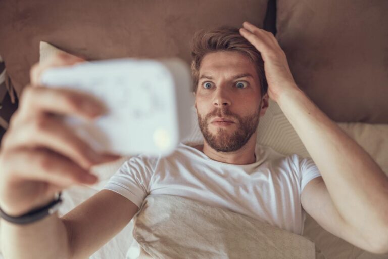 Person waking up before the alarm feeling anxious in a dark bedroom