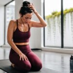 Woman resting after a hot yoga session with signs of shakiness and fatigue