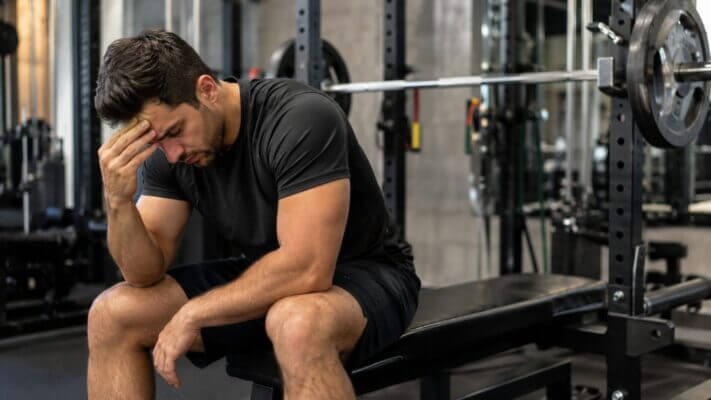 Man resting after bench press with head pressure and headache symptoms