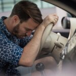 Driver feeling mentally tired after a long drive while sitting in a parked car