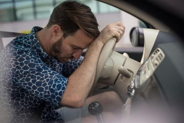Driver feeling mentally tired after a long drive while sitting in a parked car