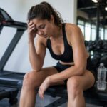 Person feeling lightheaded after an incline treadmill workout in a gym