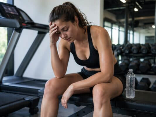 Person feeling lightheaded after an incline treadmill workout in a gym