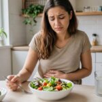 Woman feeling nauseous after eating a fresh salad at home