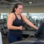 Woman slowing down during an incline treadmill workout because of nausea