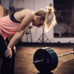 Athlete recovering after a heavy squat set near a squat rack