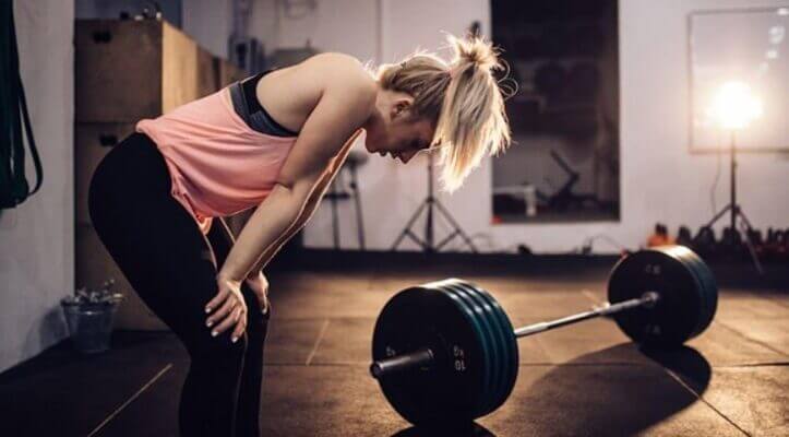 Athlete recovering after a heavy squat set near a squat rack