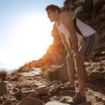 Person walking uphill and pausing to catch their breath on a trail