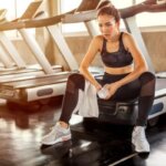Woman feeling weak after incline treadmill walking during a gym workout