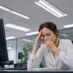 Person feeling nauseous under fluorescent office lighting
