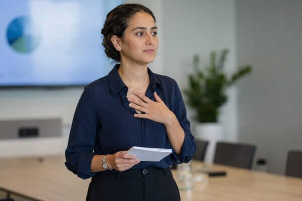Person holding presentation notes before speaking to an audience