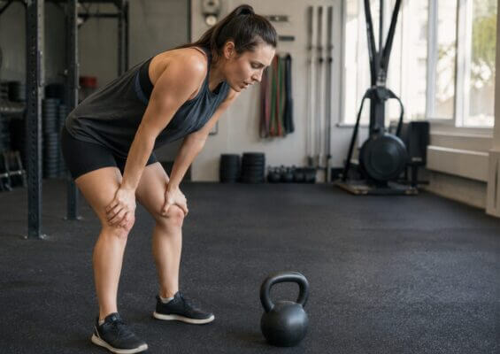 Person feeling nauseous after kettlebell swings in a gym