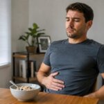 Person feeling bloated after eating oatmeal at breakfast