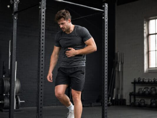 Athlete feeling nauseous after a hard pull-up set in the gym