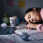 Student feeling mentally exhausted after studying late at night at a desk