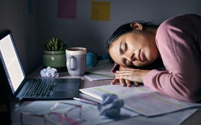 Student feeling mentally exhausted after studying late at night at a desk