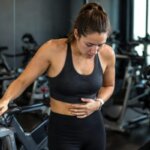 Woman recovering from nausea after an intense spin class workout