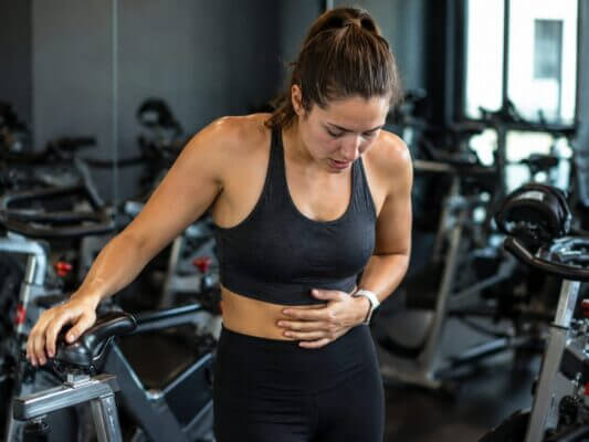 Woman recovering from nausea after an intense spin class workout