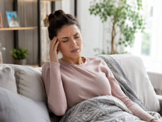 Person sitting up after a nap and feeling slightly dizzy in a bright living room