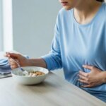 Person feeling bloated after eating yogurt at breakfast